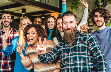 Multiethnic joyful university students or young business people looking at camera with victory gestures for a group photo - Goal achievement concept - obrazy, fototapety, plakaty