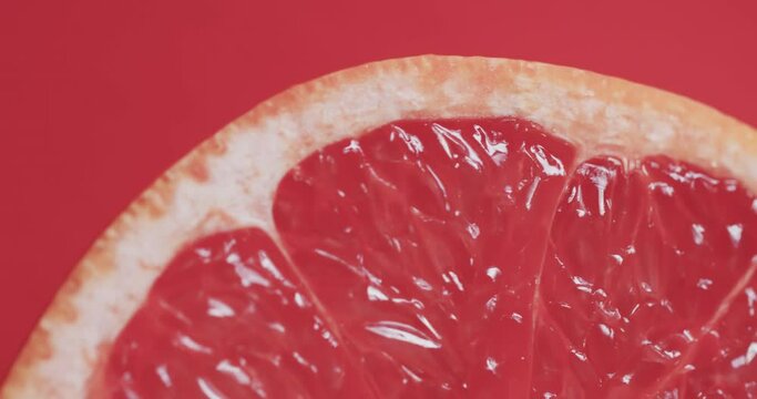 Video of sliced red grapefruit with copy space over red background