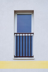 Façade d'un immeuble avec un mur blanc et grande fenêtre noire