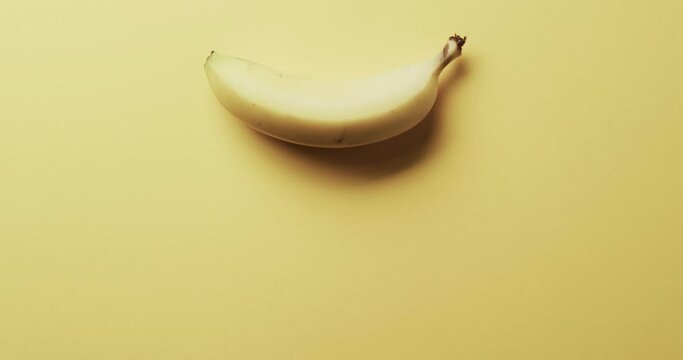 Video of banana with copy space over yellow background