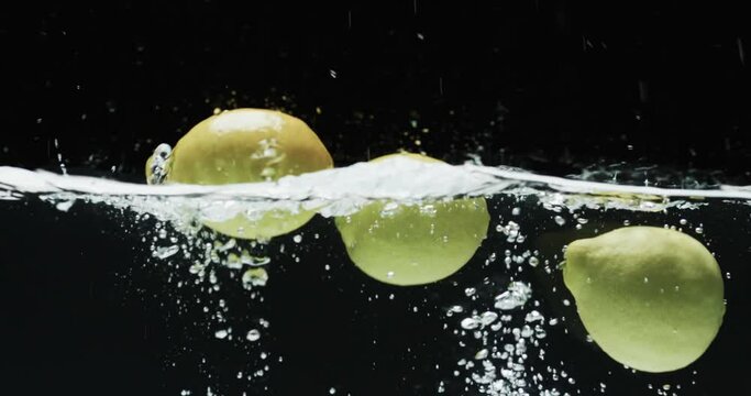 Video of three limes underwater with copy space over black background