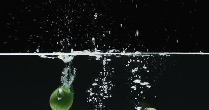 Video of two limes underwater with copy space over black background