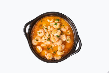 Deep black plate with handles with garlic prawns, also called Pil-pil, on a white background.