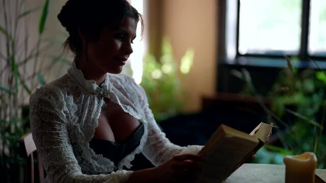 busty woman in retro gown dreaming about love and holding old book with novels in hands