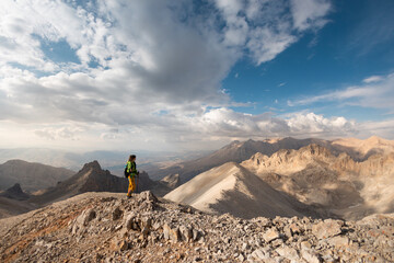 hiking in the mountains. Girl with a backpack in the mountains
