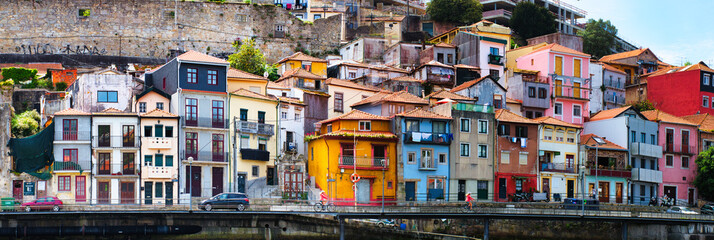 Naklejka premium A breathtaking panoramic view of the historic Ribeira district of Porto, as seen from the tranquil waters of the Douro River.