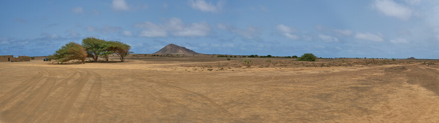 Hupe panorama landscape photo of natural dry desert with trees, house and mountain during summer, in monte leste, sal island, cape verde, cabo verde