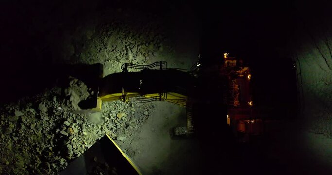 Excavator digging limestone in mining truck in open pit mine, aerial slow motion shot