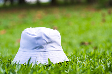 An artfully crafted mockup image portrays a white blank bucket hat in the embrace of nature,...
