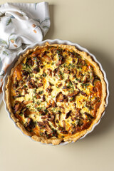 Homemade quiche with seasonal forest mushrooms Chanterelles in a round shape on a yellow background