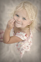 Two and half years old girl posing on sea beach with giant shell