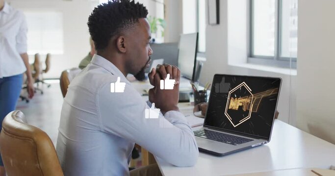 Animation of thumbs up icons over african american man looking at nft text icon on laptop