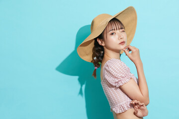 水着を着た若い女性の青背景のポートレート