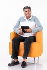 Senior man using digital tablet at white background