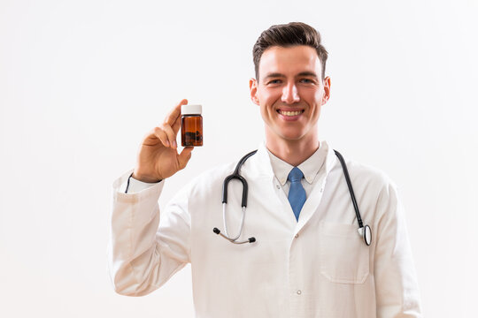 Image of doctor showing bottle of pills .	