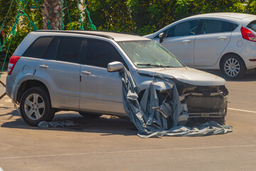 Car that was damaged in a direct head-on collision on the highway is parked in parking lot and...