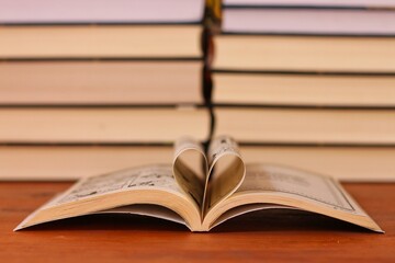 Love of books, reading. An open book with folded pages of books in the shape of a heart. Knowledge Day, Teacher's Day. Library. Reading books.