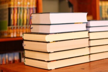 Book stack in the library room and blurred bookshelf for business and education background, back to school concept