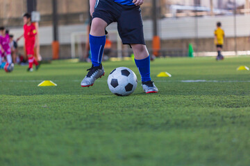 Children playing control soccer ball tactics on grass field with for training