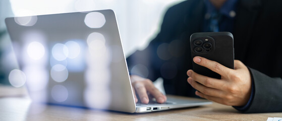 Mobile Technology in Business: Businessman Using Phone and Notebook Computer for Productivity