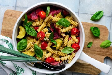Pasta with zuccini, tomato and salami and Basil  .top veiw.selective focus