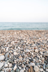 Fototapeta na wymiar Strand mit Steinen und Ausblick auf das Meer in der Hitze des Sommers