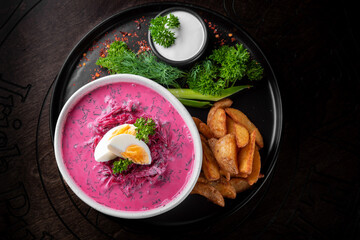 Vegetable cold soup with beet, cucumber, radsih and egg on wooden table
