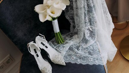 White bridal shoes, wedding rings and bouquet of white rose flowers.