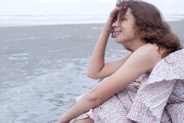 Pretty girl sitting in the morning breeze and fresh air at the beach, enjoy morning fresh air with sea view