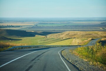 Country highway in the autumn. Empty roads among the hills