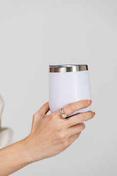 The mockup image showcases a woman in a white blank tumbler, striking a simple pose at an indoor studio, adding sophistication to your designs
