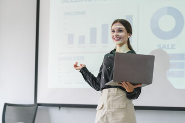 The female Chief Analyst is conducting a meeting presentation for a team of economists. The projector screen shows graphs, product sales, revenue growth strategies, and e-commerce analysis.