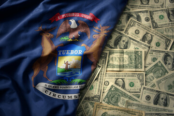 colorful waving national flag of michigan state on a american dollar money background. finance...