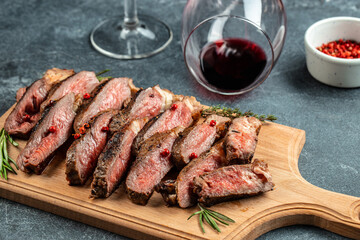 beef steaks with wine glass on a dark background. Restaurant menu, dieting, cookbook recipe top view