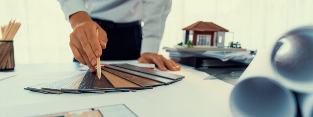 Interior architect designer at workstation table designing house interior blueprint and choosing...