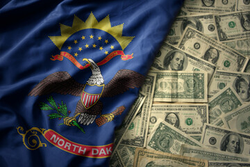 colorful waving national flag of north dakota state on a american dollar money background. finance...