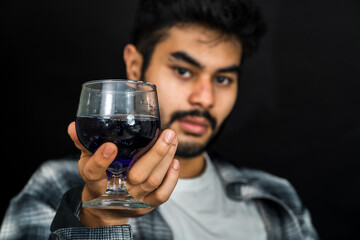 Professionally captured, the image showcases a man elegantly holding a purple colored drink, adding a touch of sophistication to your brand imagery