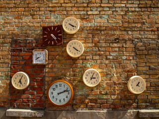 Round clocks hanging on the brick wall