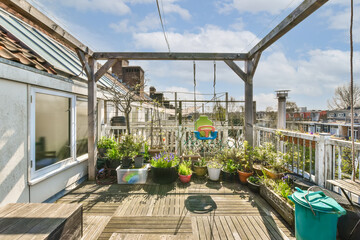 a roof garden with potted plants on the deck and an overhead view of the city in the background,...
