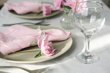 Fototapeta na wymiar Table setting with light green ceramic plates and pink peonies