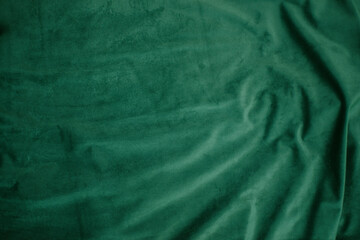 emerald velor with folds background image, green shiny fabric silk for background web design...