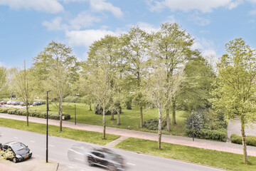 an empty street with cars driving on the road and trees in the fore - image taken from google street view