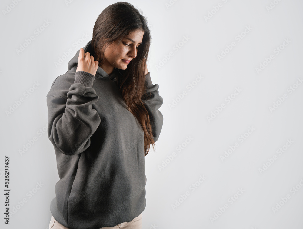 Wall mural brunette woman wearing a sweatshirt with a hood. beautiful girl blank one color jumper. - Wall murals