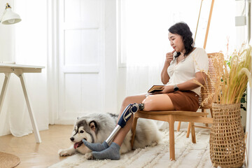 Woman with prosthetic leg  sitting in chair in living room at home. Relaxed, happy woman at home...