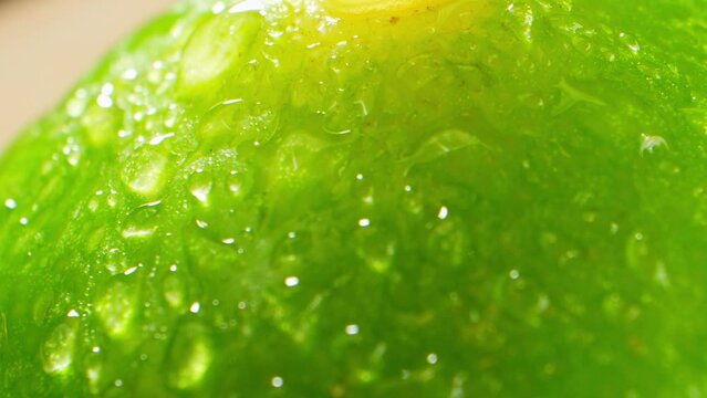 Green lemon, captured through a probe lens, showcases vivid hues of lime and yellow. Its textured surface reveals freshness and tang, enticing the viewer with a zesty burst of nature's vibrancy. 
