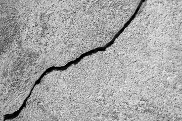 Obraz premium Big long winding ascending crack on old plastering wall. Copy space. Black and white photo. Selective focus.