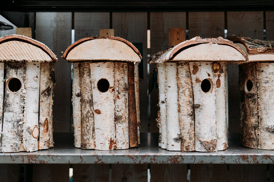 Buying a wooden nesting box for the birds in the garden. Bird houses made of birch for sale in the store