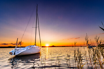 łódka na jeziorze o zachodzie słońca - obrazy, fototapety, plakaty