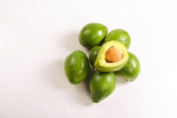bunch of avocado fruit and split avocado isolated on white, top view