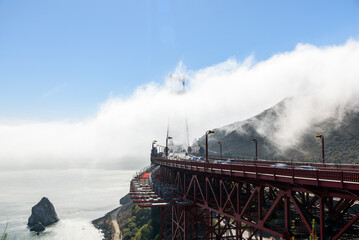 Traffic on Golden Gate bridge partly shrouded in fog on an autumn day